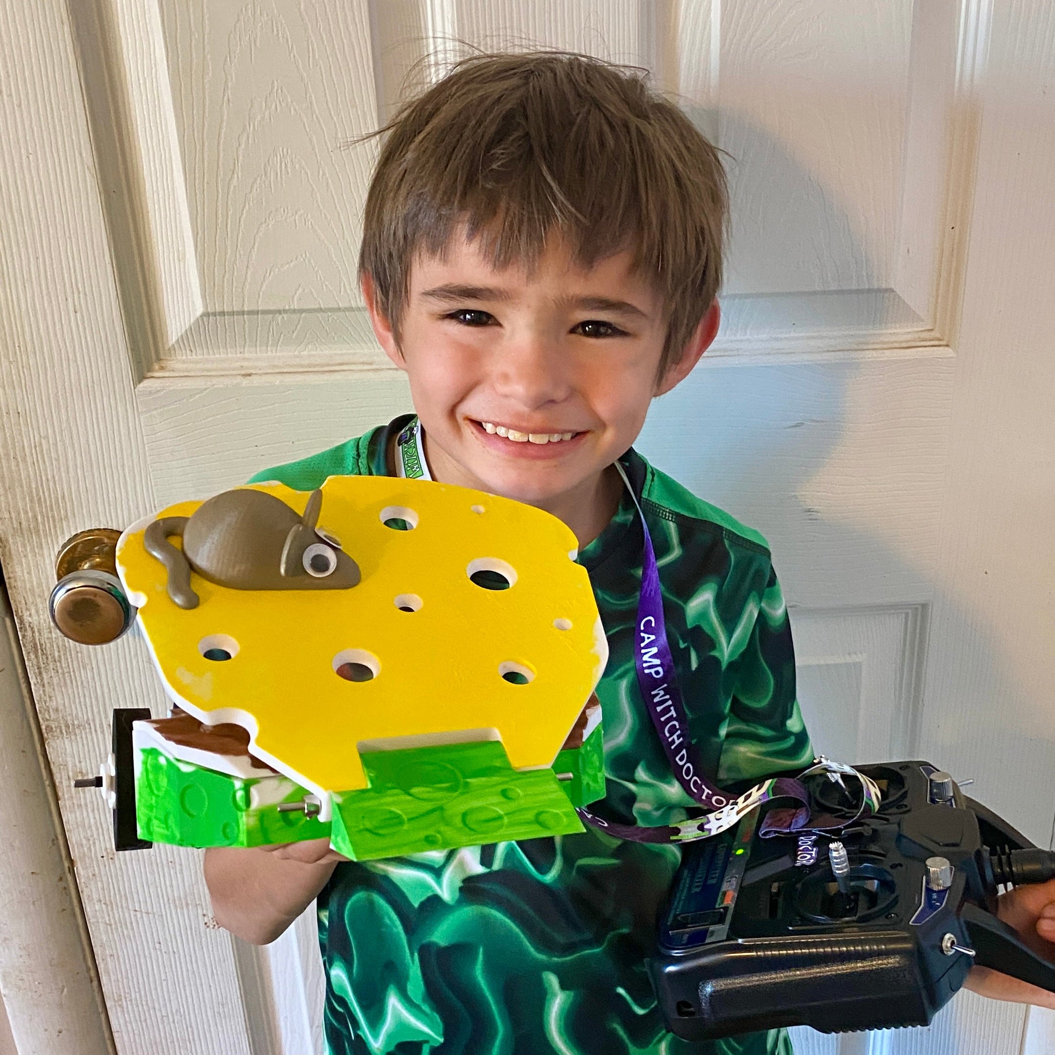 Child proudly holding a RoboClash robot that he built himself.